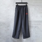 Black drawstring pants with red BALENCIAGA heart logo at front.