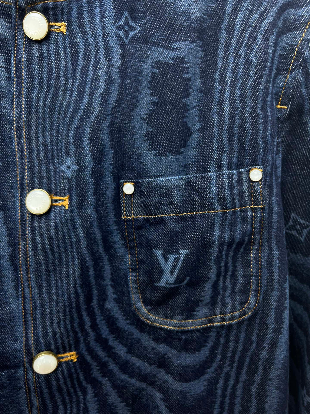 Blue denim jacket chest pocket with flap and round snap buttons