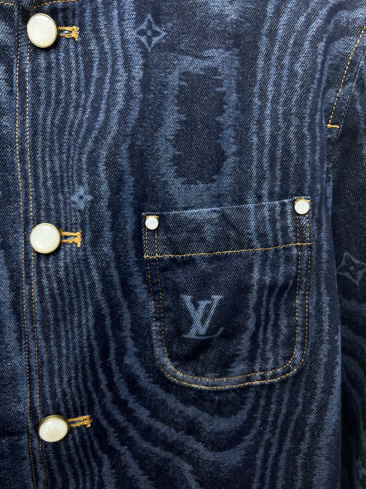 Blue denim jacket chest pocket with flap and round snap buttons