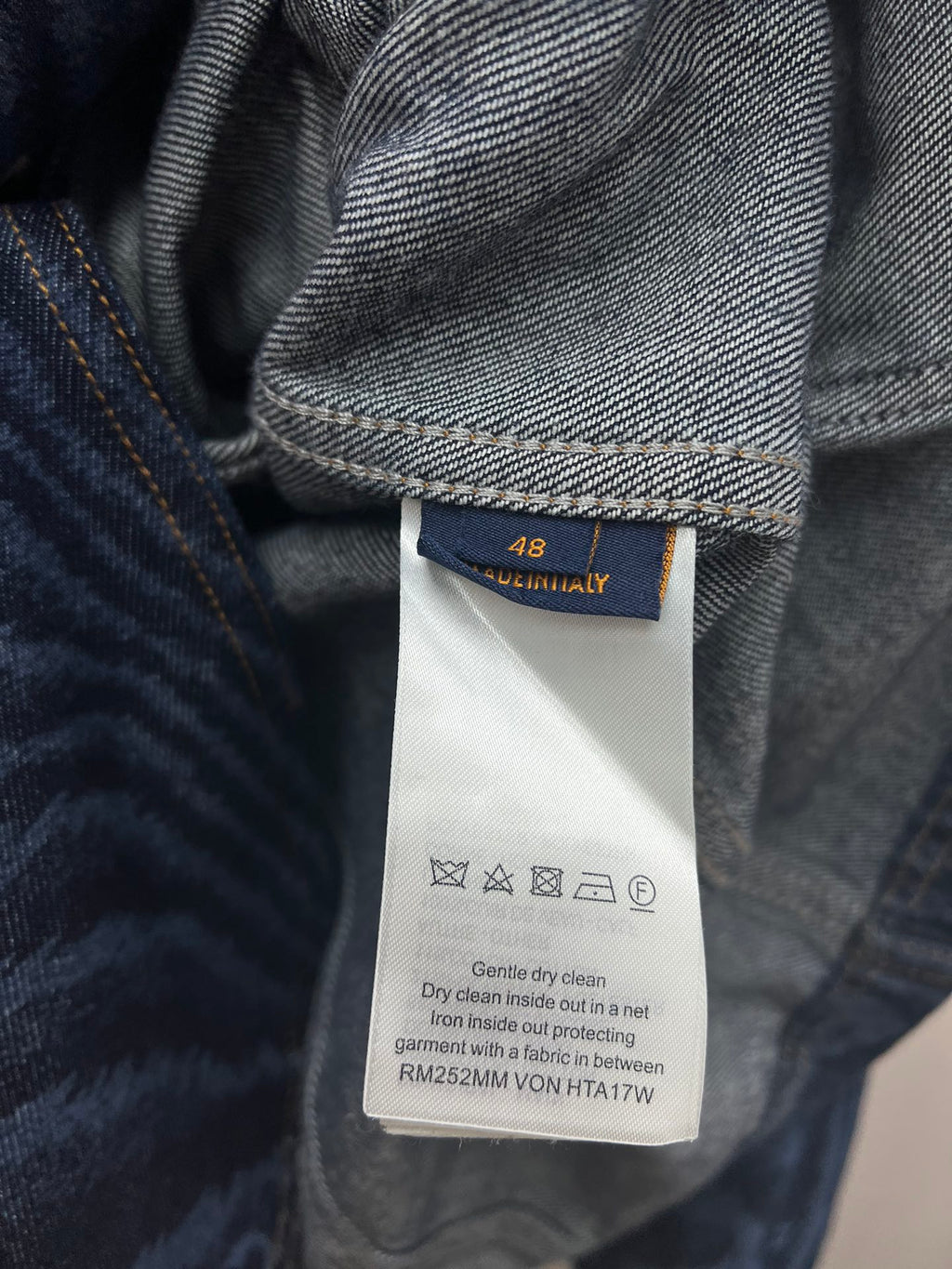 Blue jacket care tag with size 48 and washing instructions