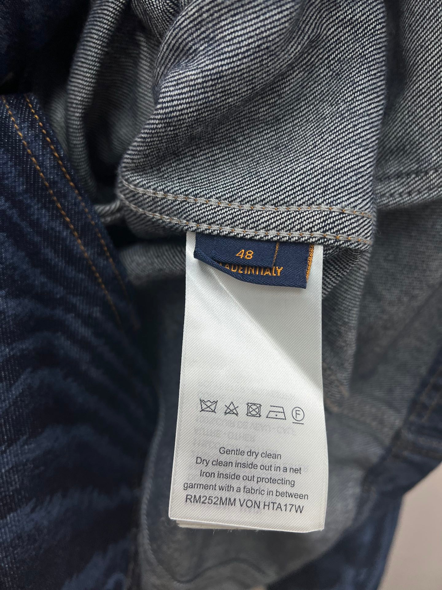 Blue jacket care tag with size 48 and washing instructions