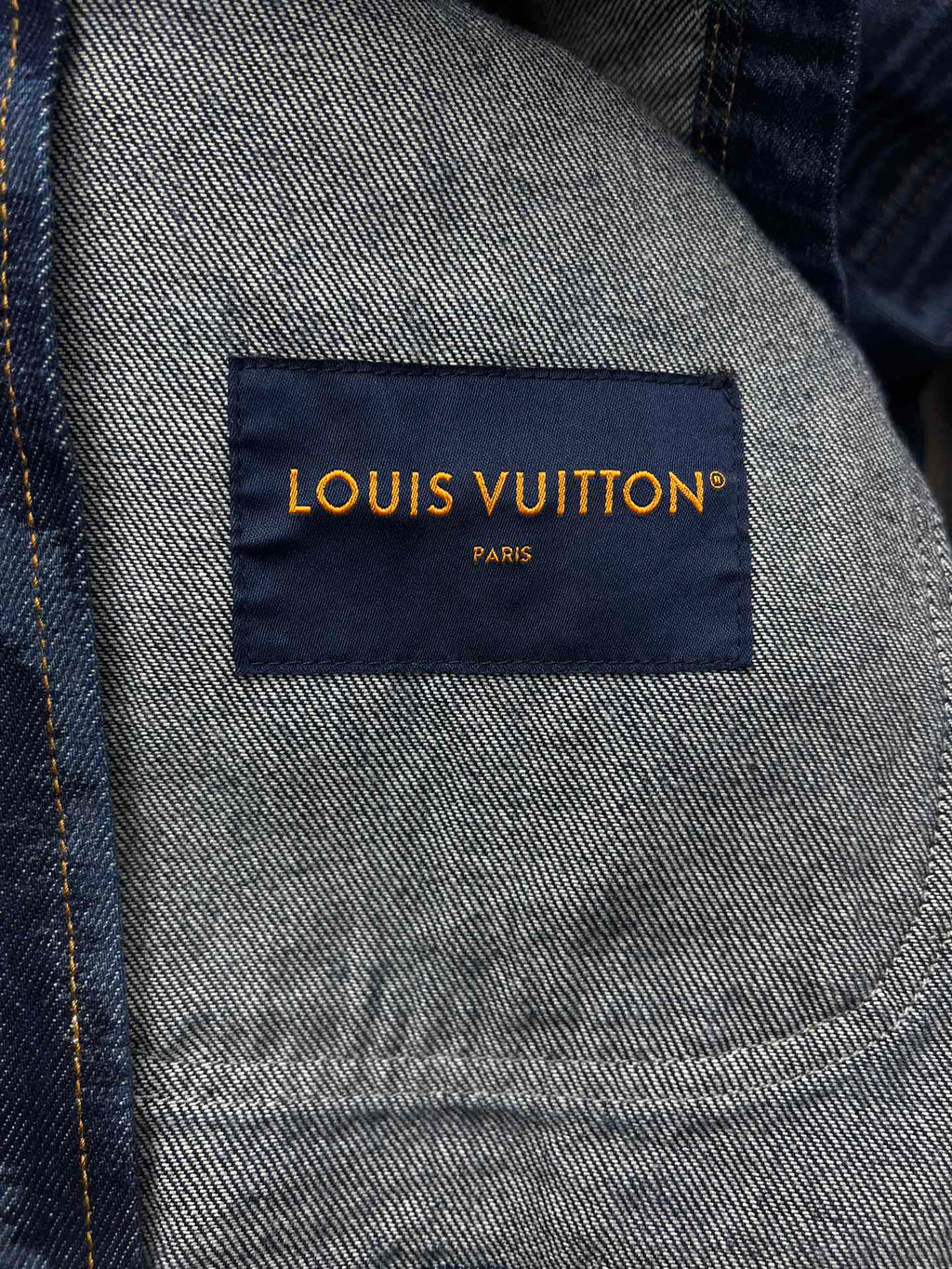 Blue jacket interior label reading LOUIS VUITTON PARIS