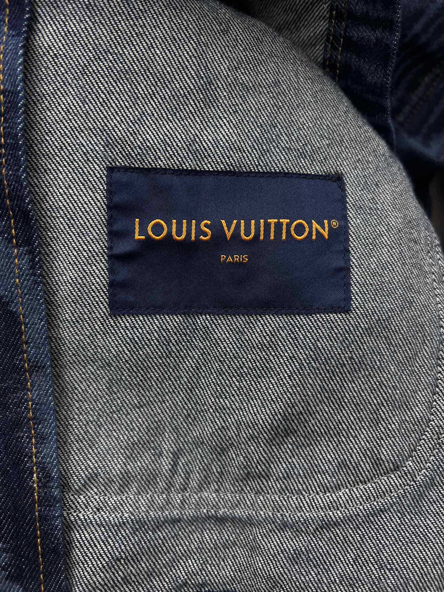 Blue jacket interior label reading LOUIS VUITTON PARIS