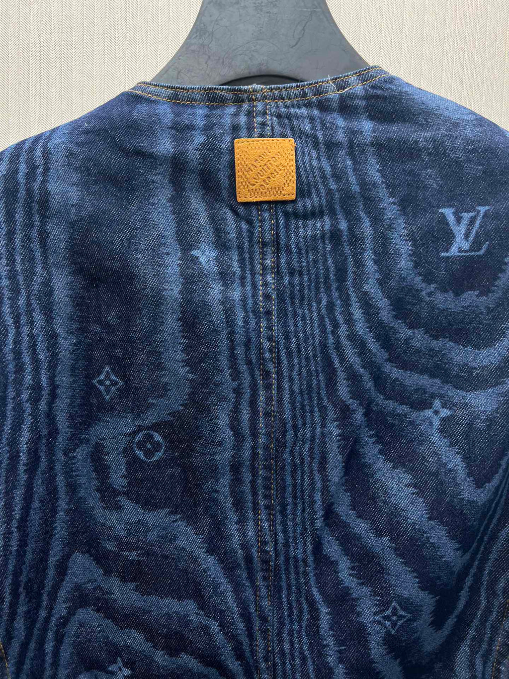 Back of blue denim jacket with rectangular leather-look patch