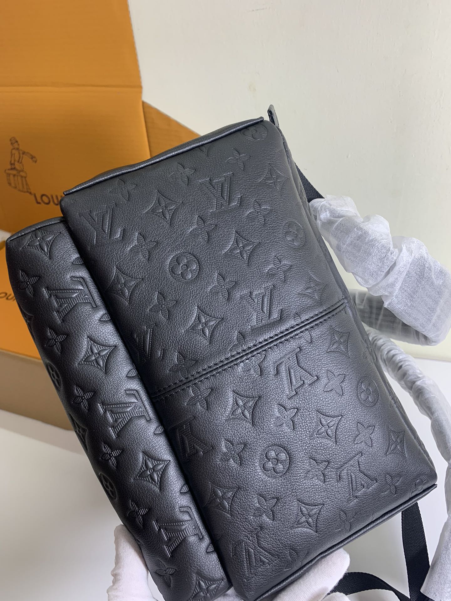 Louis Vuitton monogram backpack with front panel seam and adjustable strap, dark embossed.
