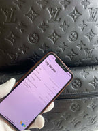 Louis Vuitton bag exterior with all-over monogram embossing and phone tag app