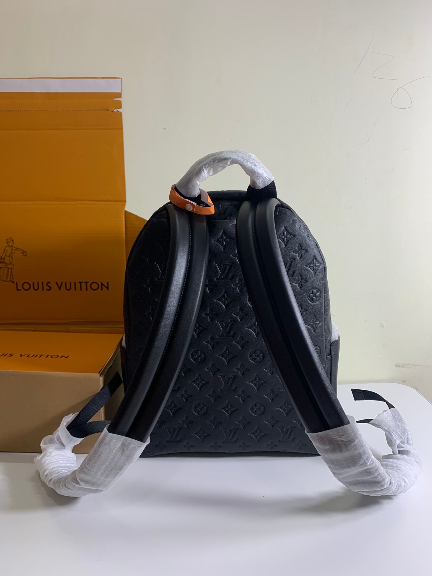 Louis Vuitton monogram backpack with two back straps and full back panel, dark embossed.