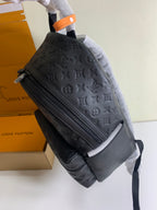 Louis Vuitton monogram backpack with long front zip and side profile, dark embossed leather.