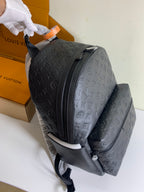 Louis Vuitton monogram backpack with front zip and padded straps, dark embossed leather.
