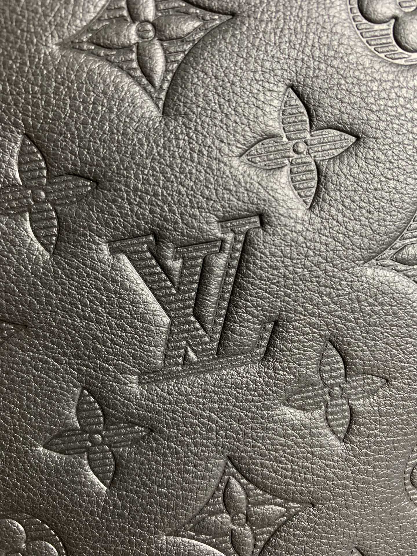 Louis Vuitton monogram leather close-up showing embossed pattern on textured surface.