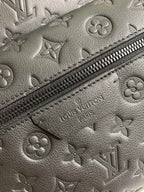 Louis Vuitton monogram leather close-up with zipper trim and embossed LV details.