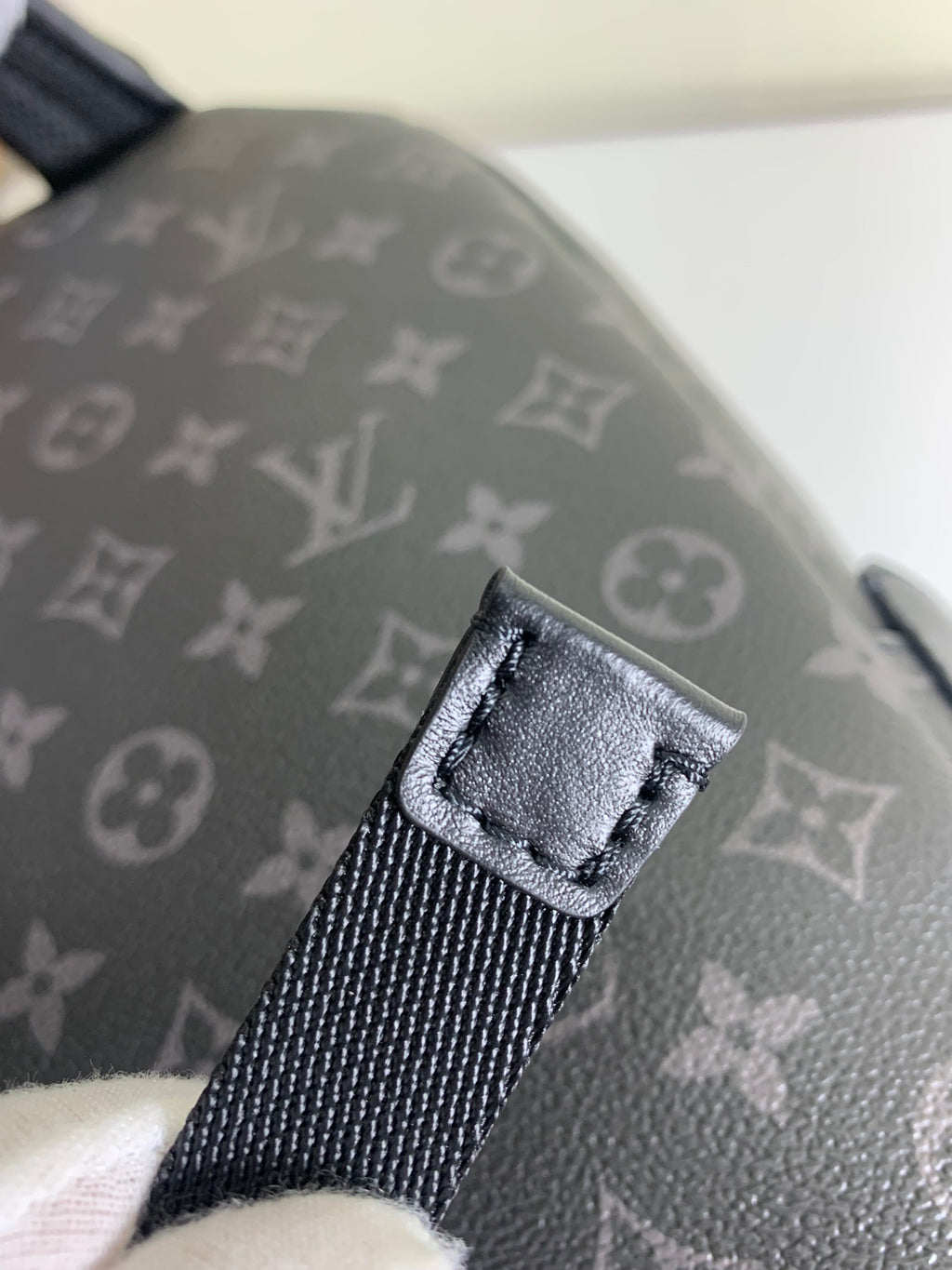 Louis Vuitton bag strap attachment with stitched tab and dark webbing