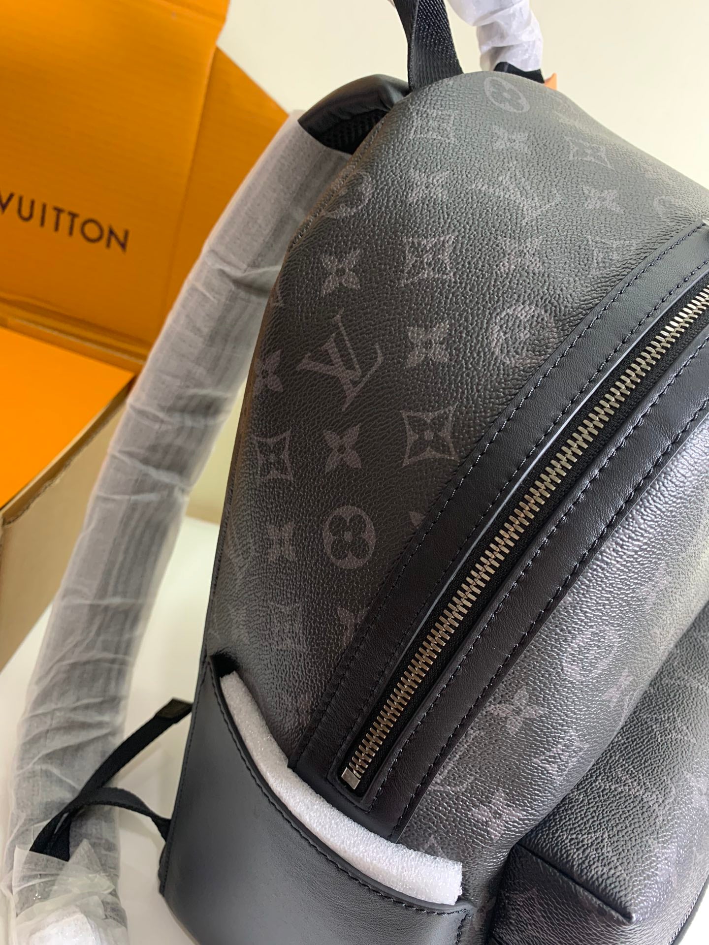 Monogram backpack side view with silver zipper and smooth dark trim