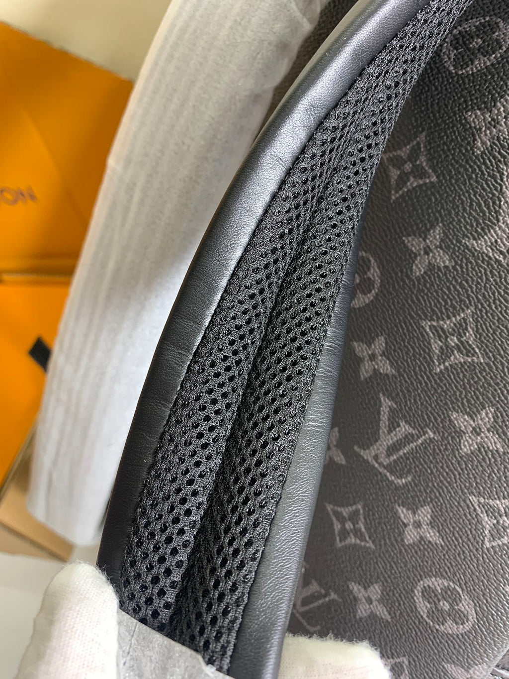 Monogram backpack close-up of perforated strap panel and dark leather trim