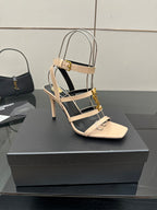 Beige strappy high-heel sandal with gold buckle and ankle slingback strap.