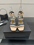 Beige strappy high-heel sandals with gold hardware and ankle slingback.