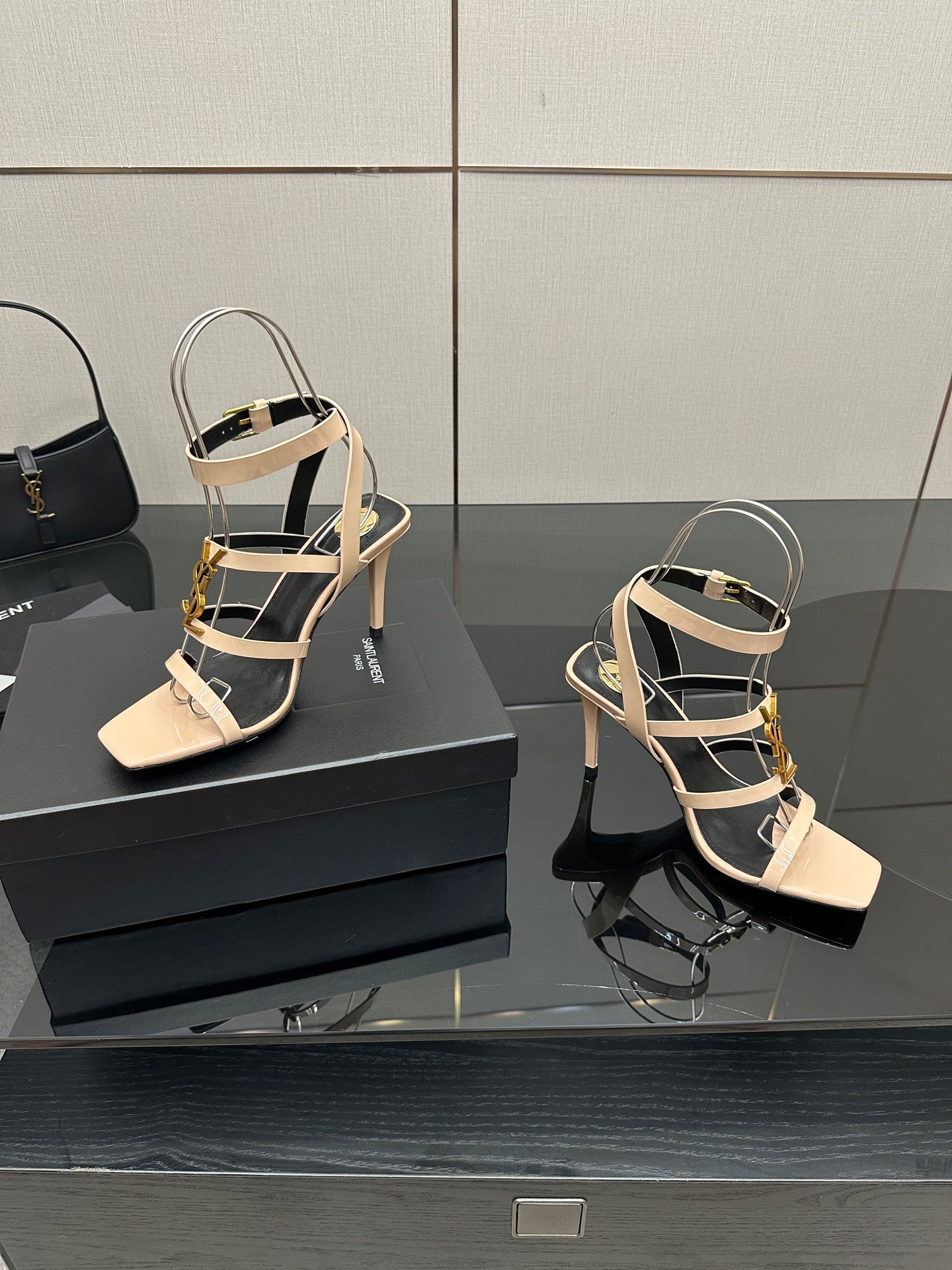 Beige strappy high-heel sandals with gold trim, open toe, and thin heel.