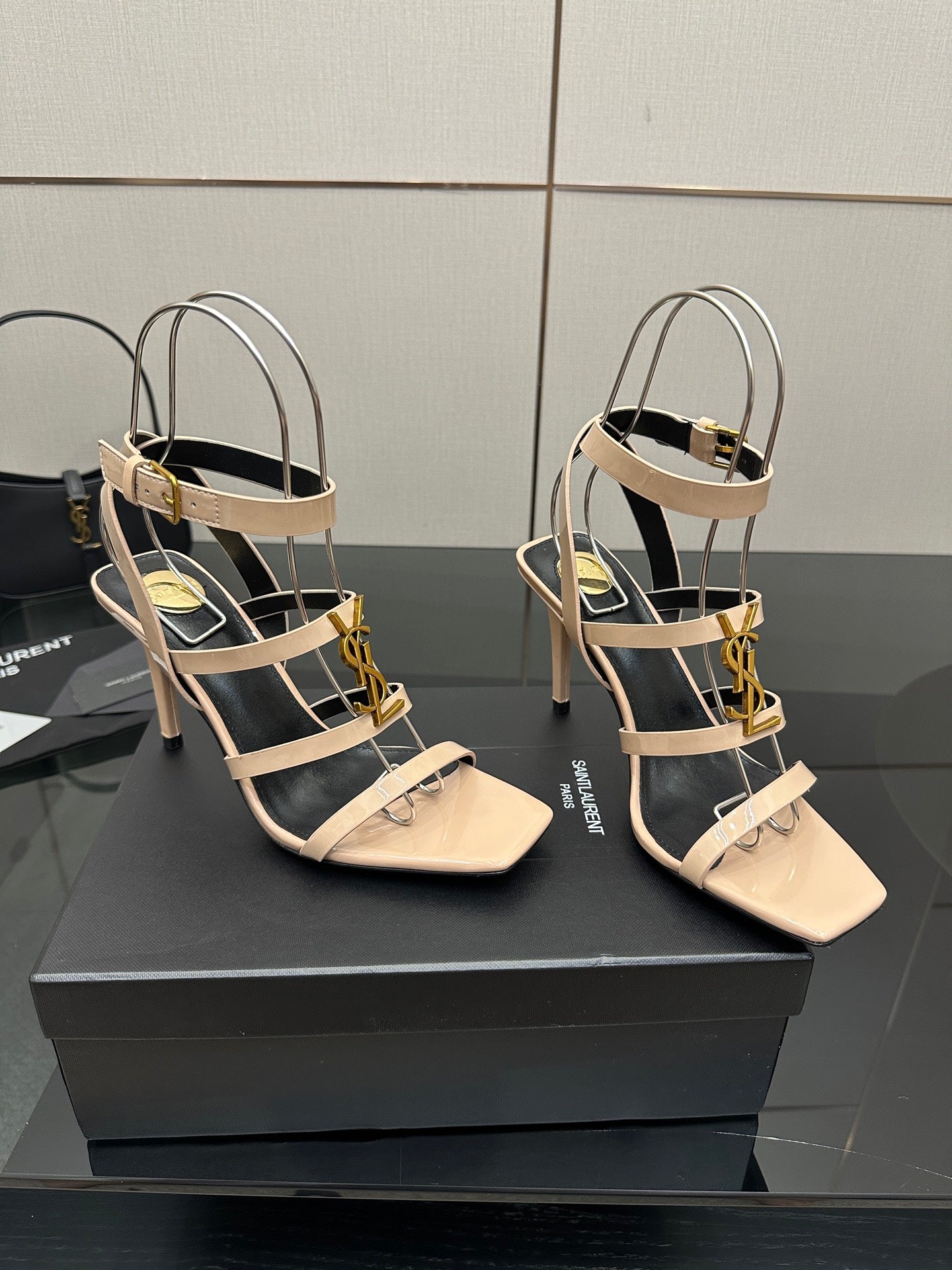 Beige strappy high-heel sandals with gold chains and open-toe design.