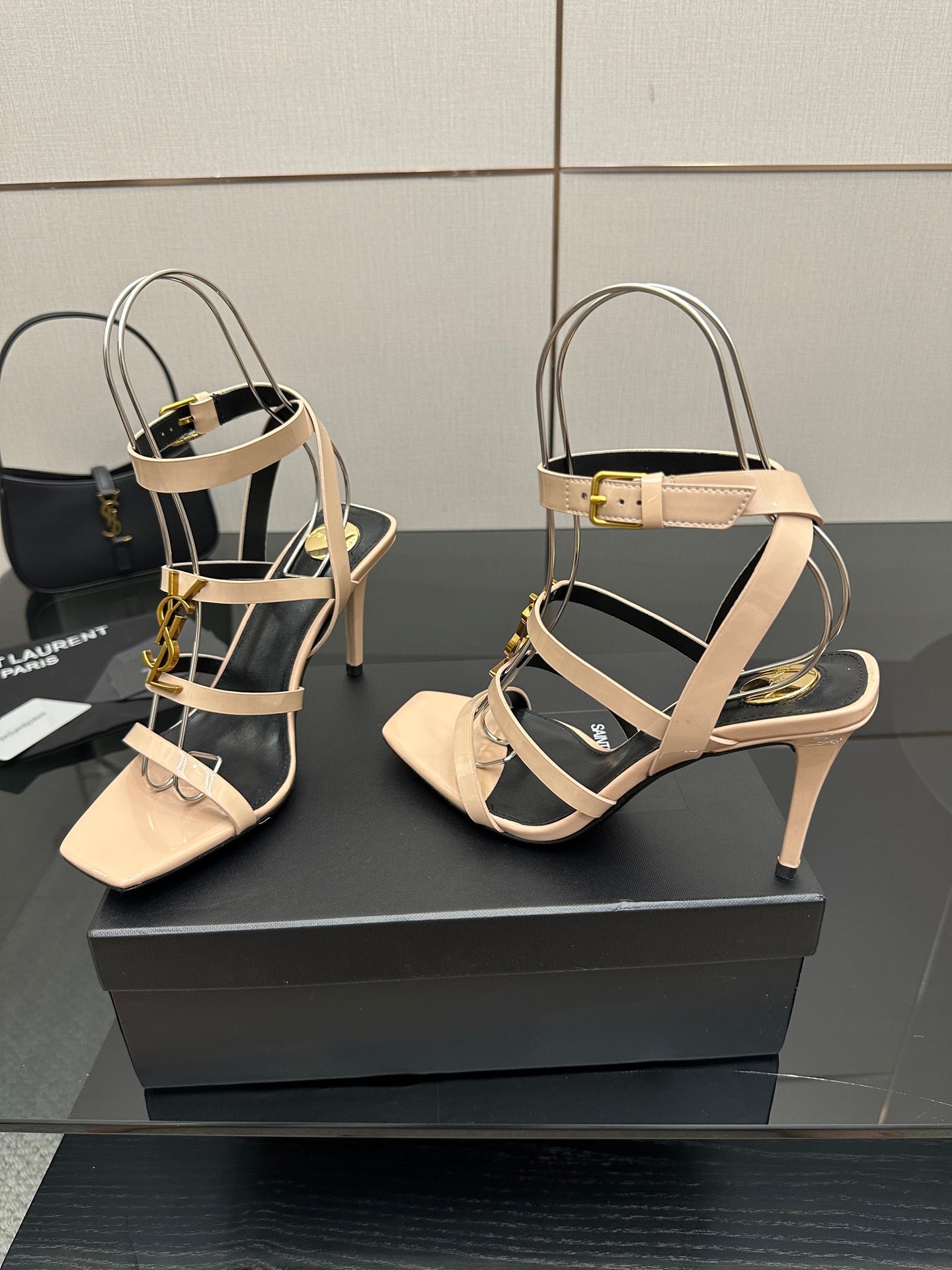 Pair of beige strappy high-heel sandals with gold buckles and ankle strap.