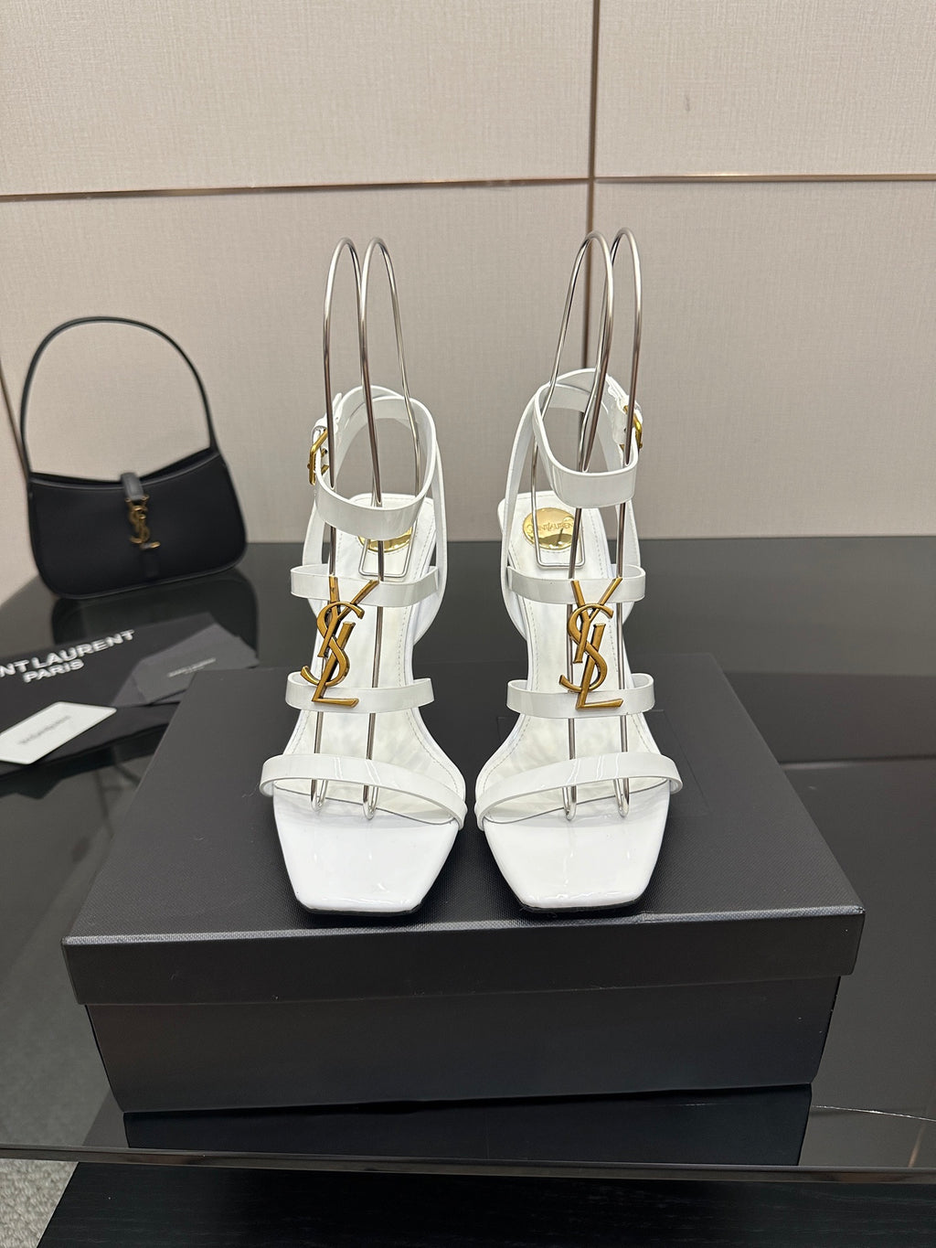 White high-heel strappy sandals with gold-tone hardware, open toe and thin ankle straps.