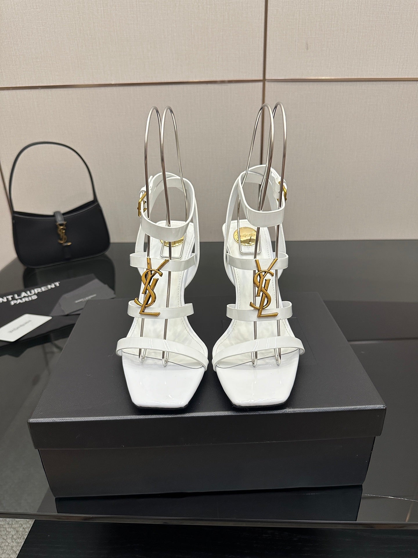 White high-heel strappy sandals with gold-tone hardware, open toe and thin ankle straps.