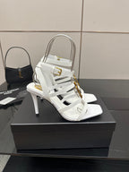 White open-toe high-heel sandals with thin straps and gold-tone buckle detail.