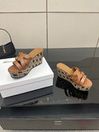 Tan leather platform sandals with gold buckles and patterned woven wedge sole.