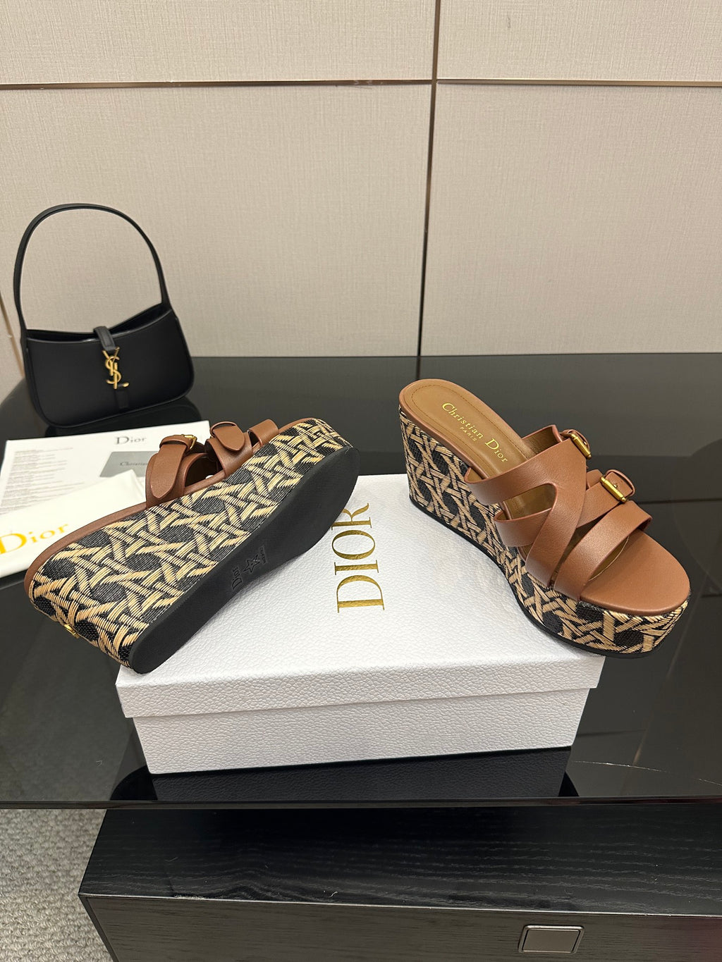 Tan leather wedge sandals with logo footbed, gold buckles, and patterned woven platform.