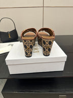 Platform sandals with tan straps and patterned heel area with gold buckles.