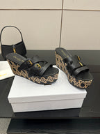 Pair of black wedge sandals with wide straps and patterned platform