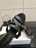 Black slide wedge sandal detail with gold buckles and patterned sidewall