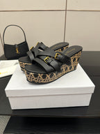 Black slide wedge sandals with patterned platform and gold buckles