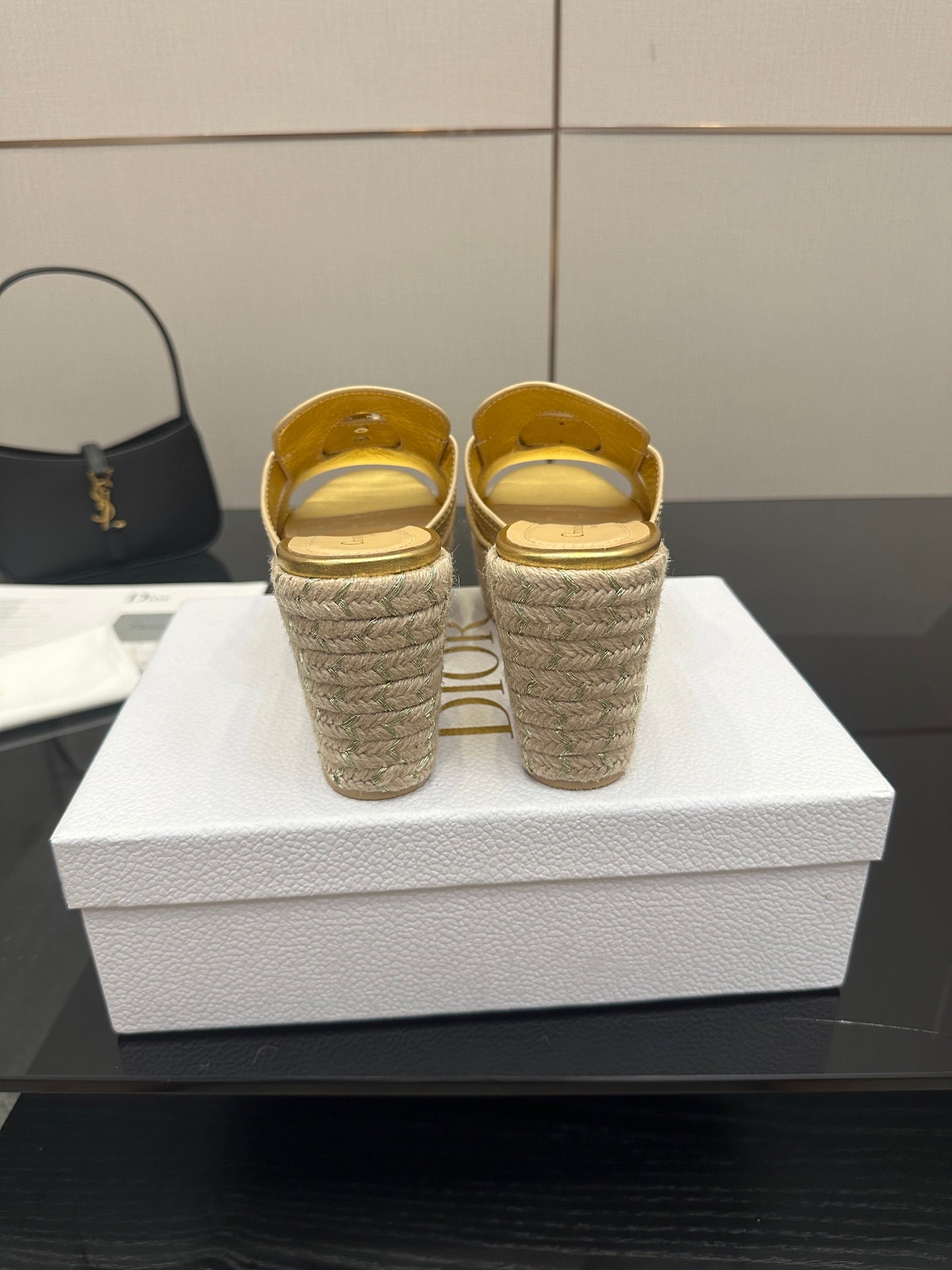 Back view of gold leather wedge mules with open heel and jute espadrille soles.