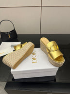 Pair of gold leather wedge mules with buckle detail and jute espadrille platforms.
