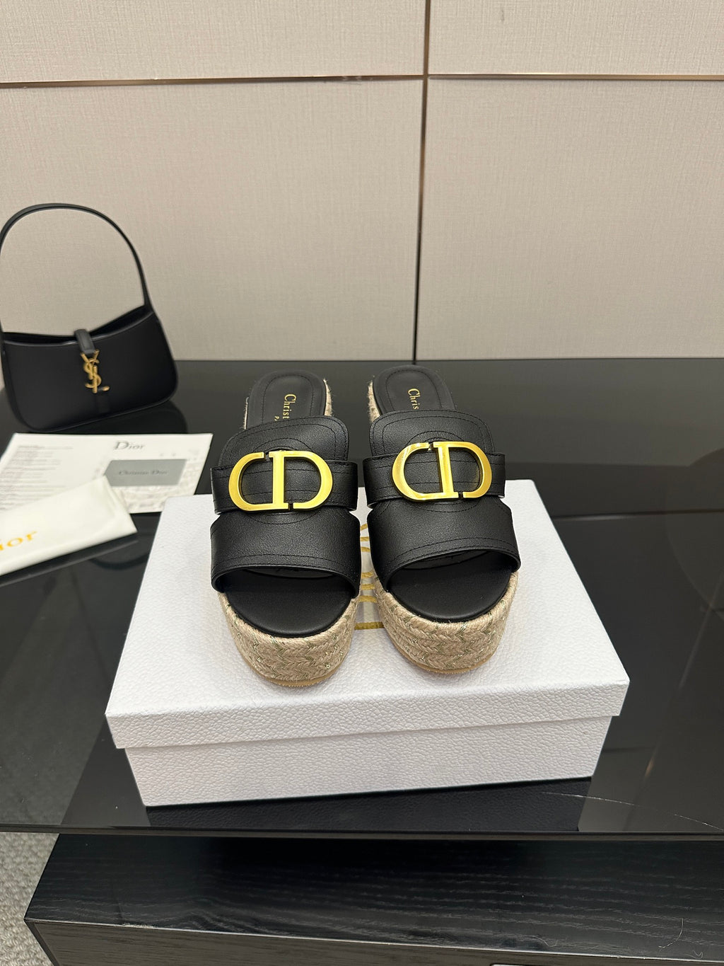 Black leather wedge mule with gold Dior-style buckle, jute platform, open toe.