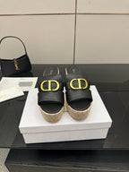 Black leather wedge mule with gold Dior-style buckle, jute platform, open toe.