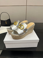 Silver mule sandals on jute wedge with gold buckle across the strap