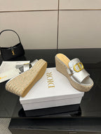 Silver wedge mule sandals with gold buckle strap and textured jute platform, side view