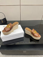 Brown leather platform wedge sandals with gold D buckle; espadrille-textured soles