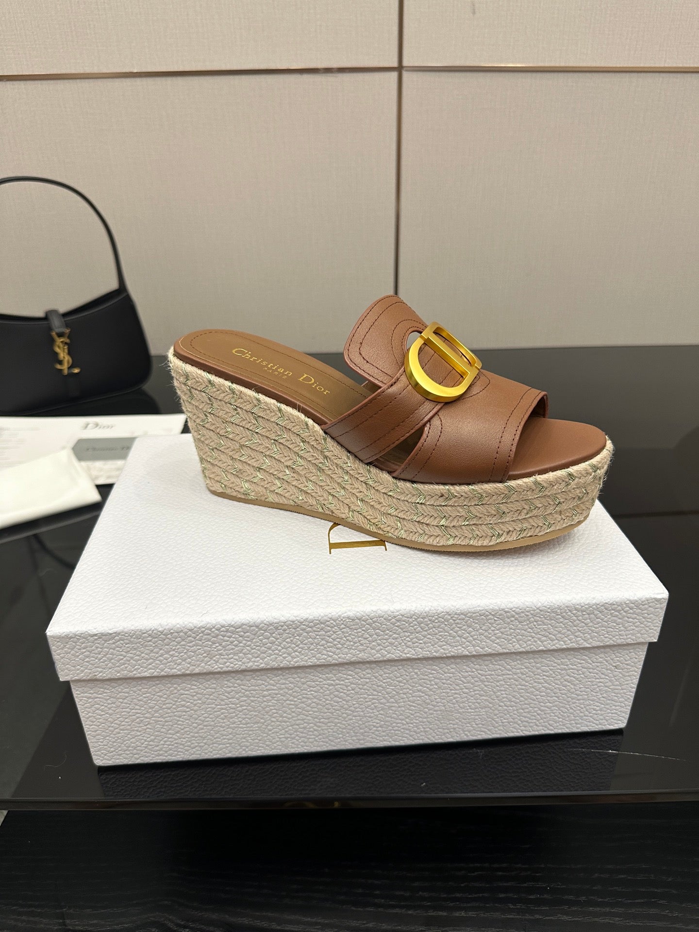 Brown leather wedge slide sandals with gold D buckle on textured espadrille wedge