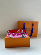 Louis Vuitton belt with pink monogram strap and LV buckle, laid on box.