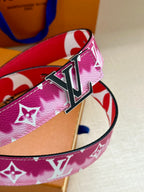 Louis Vuitton belt detail with pink monogram strap and metal LV buckle.