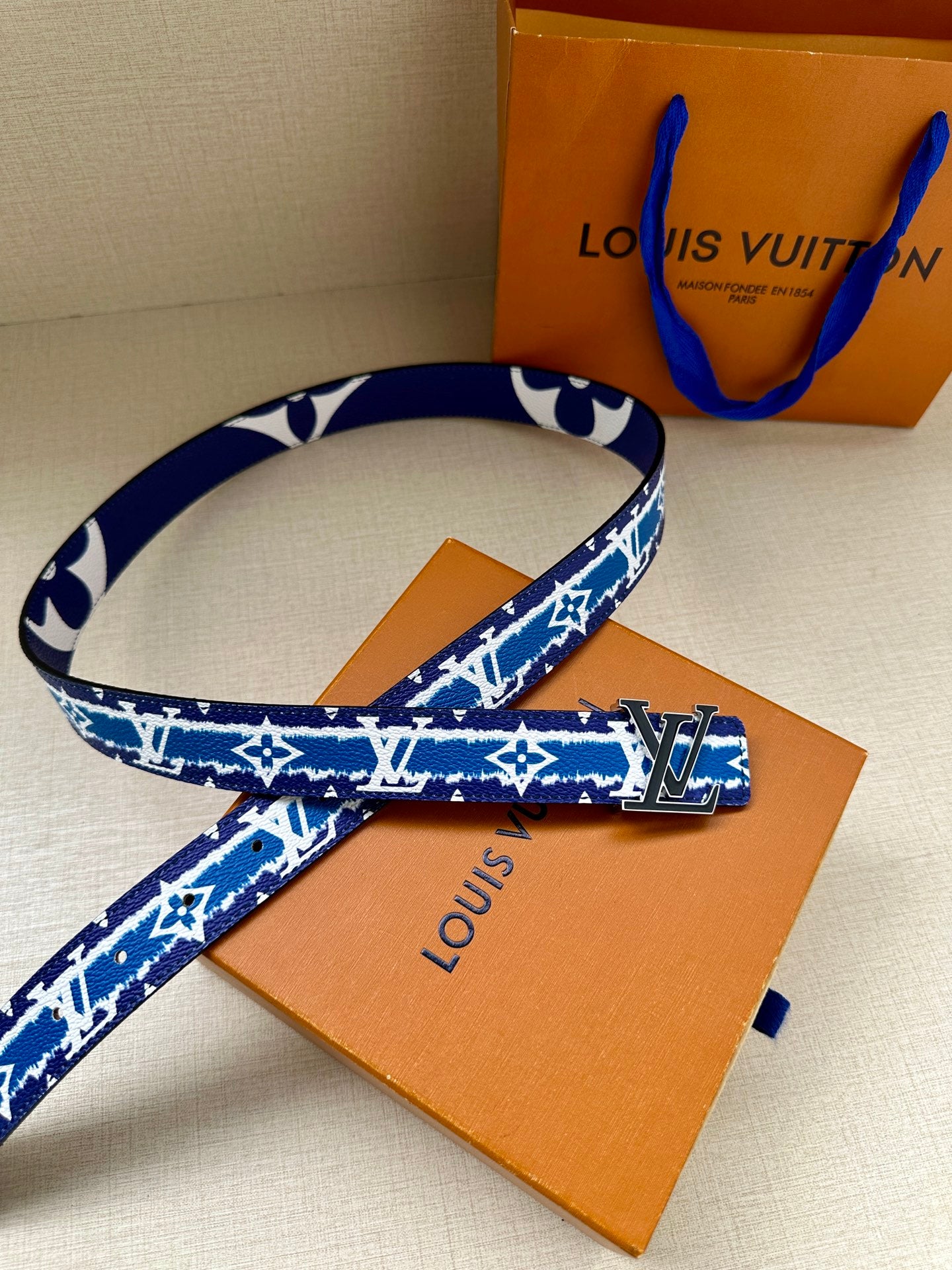 Blue and white monogram belt with gold buckle and orange Louis Vuitton box