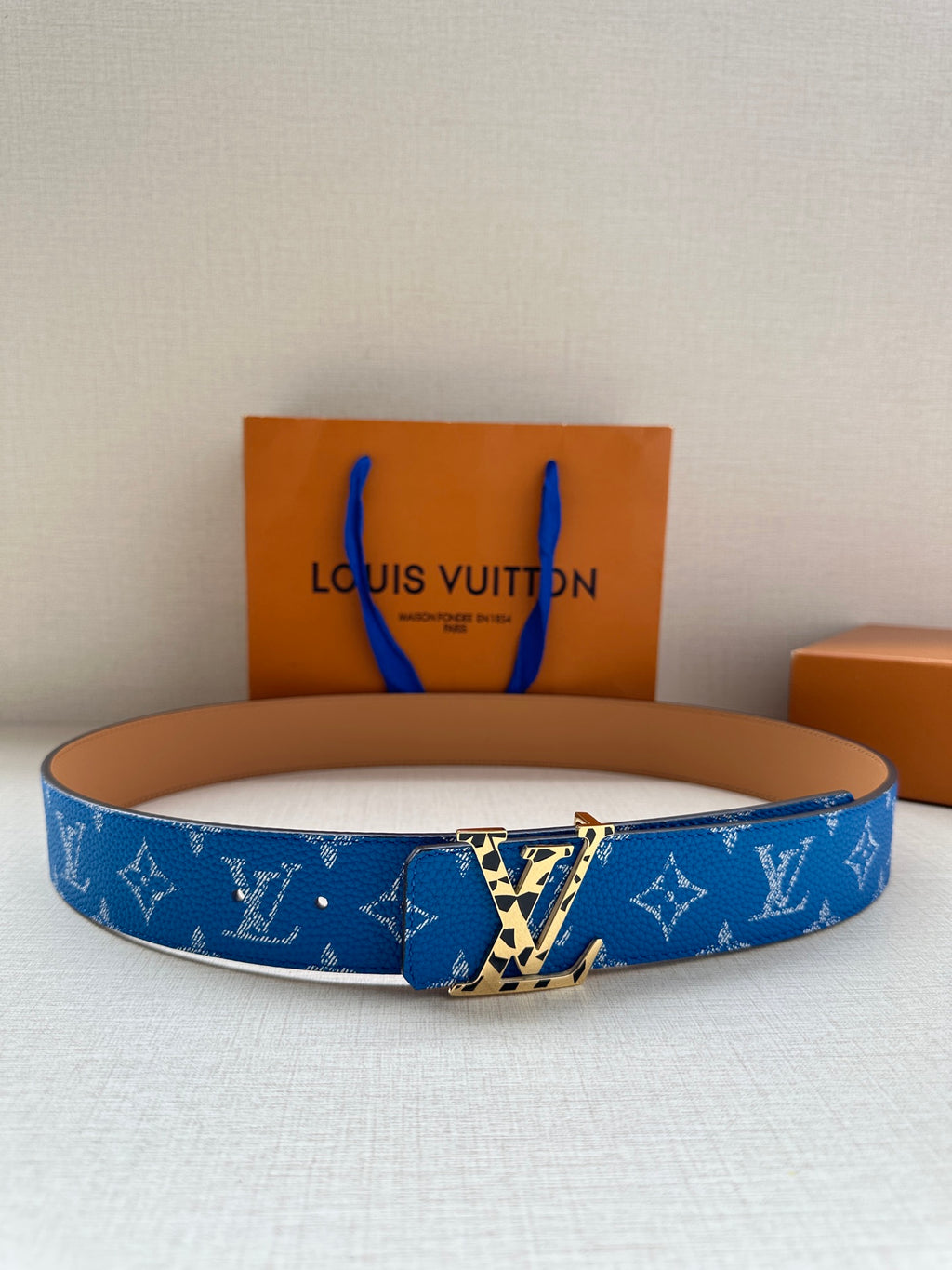 Blue monogram leather belt with gold-tone LV-style buckle and tan edge trim