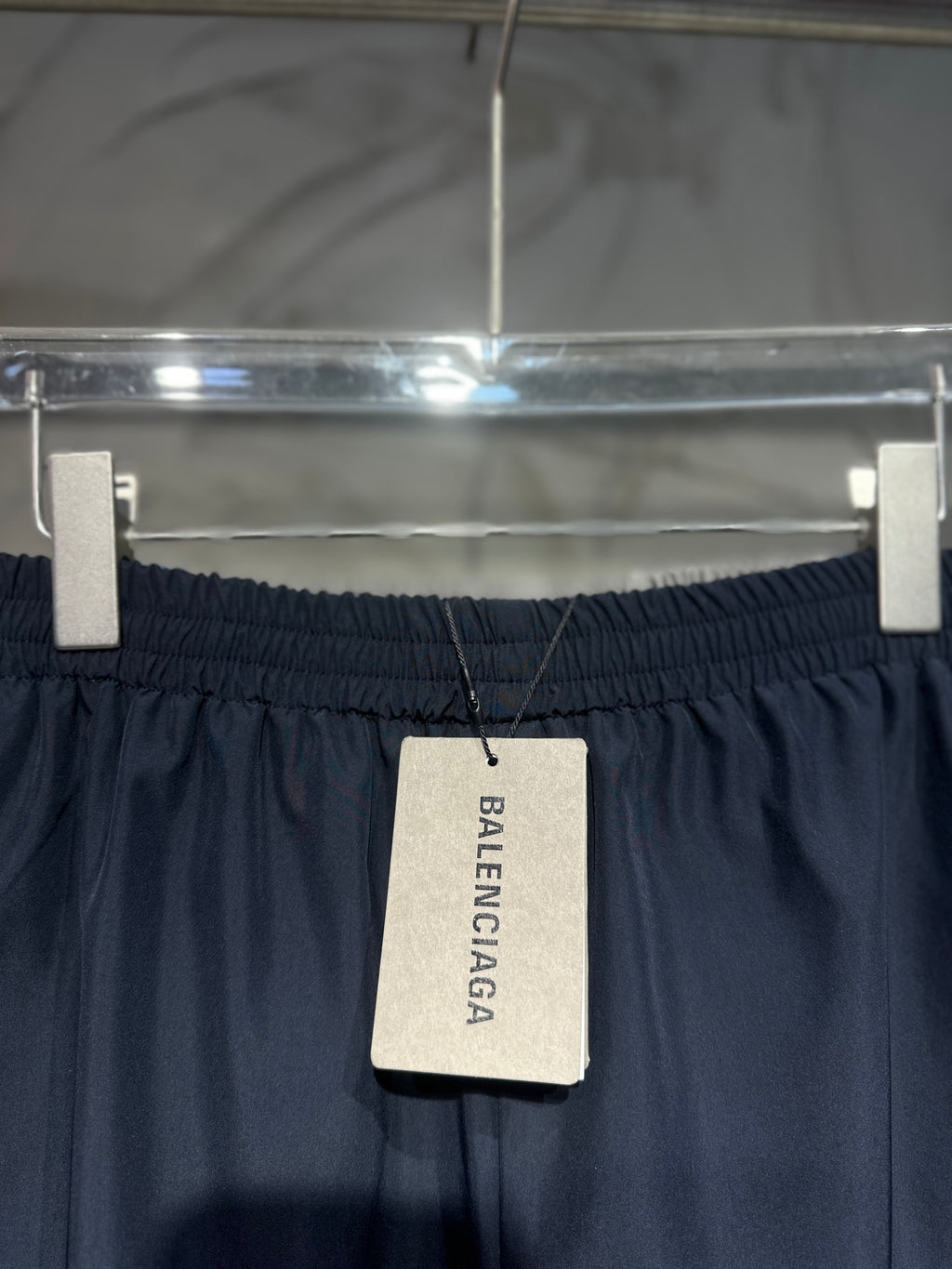 Balenciaga pants with black elastic waistband and hanging Balenciaga brand tag
