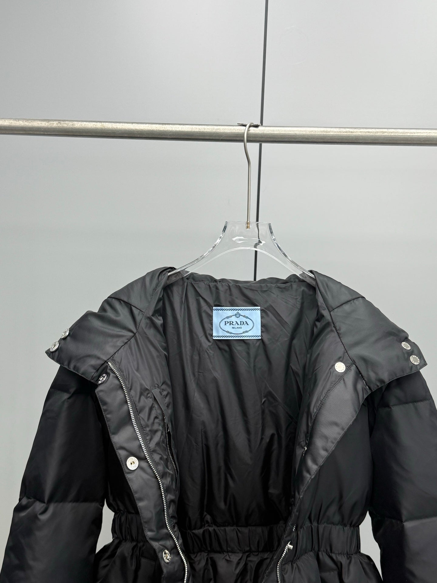 Prada black puffer coat with belt and hood, front view with interior tag