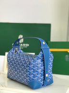 Blue Goyard-pattern satchel bag with side handles and textured leather bottom.