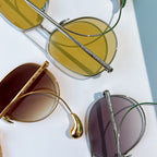 Assorted gold and silver sunglasses with tinted lenses, shown from above