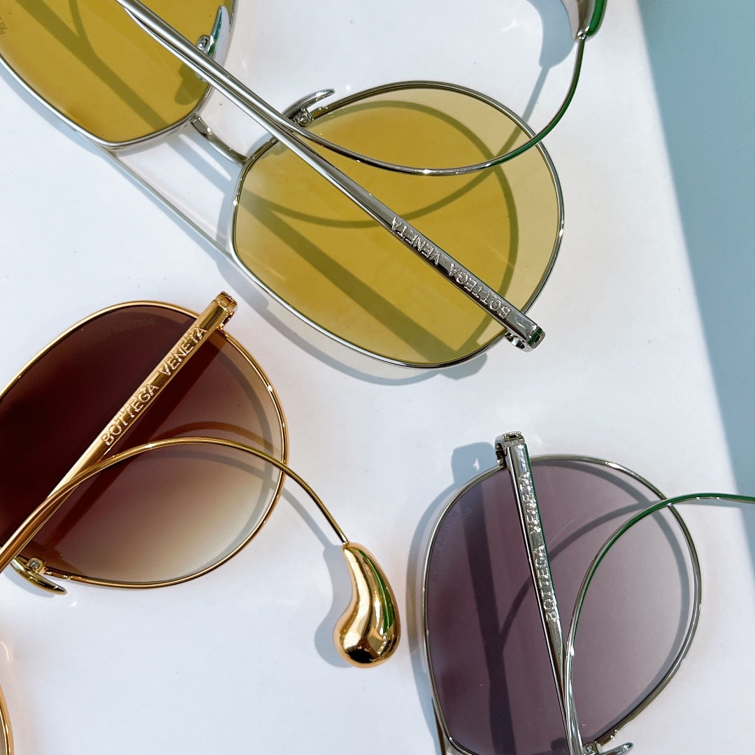 Assorted gold and silver sunglasses with tinted lenses, shown from above