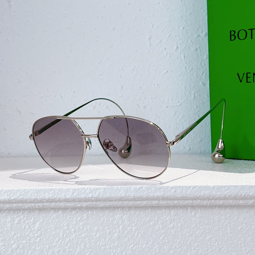 Gold-frame sunglasses with purple tint lenses and small metal side detail